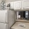 Spacious and well lit kitchen with wood floors and stainless steel appliances 